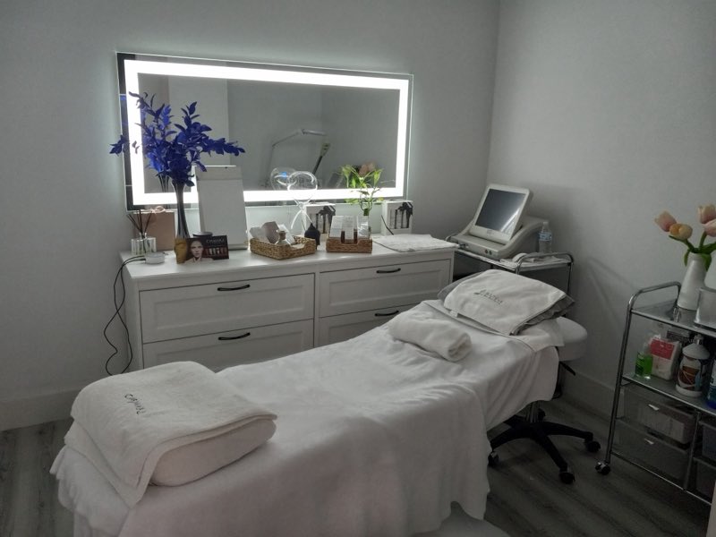 Bright, private spa treatment room with lit mirror at Beauty Energy Salon & Spa